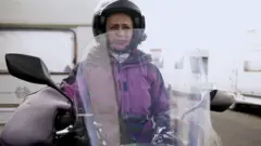 Célia Campos emjogando betfairmoto, paradajogando betfairfrente ao trailer onde mora