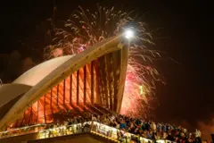 La gente disfruta de los fuegos artificiales de Nochevieja en la Ópera de Sídney el 31 de diciembre de 2025 en Sídney, Australia.