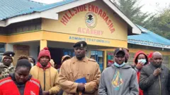 Abantu bahagaze imbere y'inyubako y'ishuri