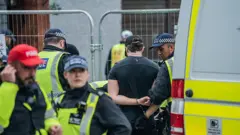 İngiliz polisi bir şüpheliyi gözaltına alıyor.