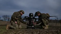 Двое украинских военнослужащих с тяжелым ударным дроном на земле (фото 26 марта)