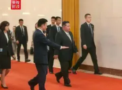 정장차림의 북한 김정은 국무위원장이 시진핑 중국 국가주석과 회담을 위해 수행원들과 이동하고 있다. 