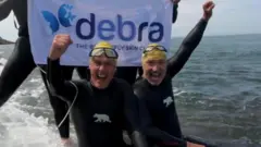 گریم سونس (راست) به منظور جمع ‌آوری کمک برای موسسه خیریه دبرا یوکی در کانال مانش شنا کرد