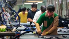 يسعى العمال في مصنع ملابس شركة Thai Son S.P. لإنتاج منتجات للعملاء العالميين، في ثو دوك، هو تشي منه، فيتنام، في 21 يونيو 2025. 