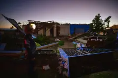 Casas destruídas e um homem olhando para destruição