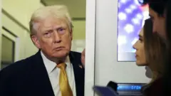 President Donald Trump speaks to the media aboard Air Force One en route to Washington, DC on January 04, 2026.