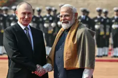 O presidente russo Vladimir Putin cumprimenta o primeiro-ministro indiano Narendra Modi com um aperto de mãos