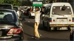 Hoton wani matashi yana sayar da ruwa a titi