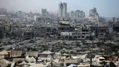 Una imagen de tiendas de campaña utilizadas como refugios temporales por palestinos desplazados se instalan cerca de edificios dañados por la guerra en la ciudad de Gaza.