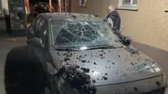 Обсыпанный обломками автомобиль с разбитым ветровым стеклом
