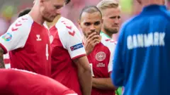Martin Braithwaite looks on as Christian Eriksen receives treatment
