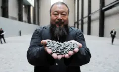 Ai Weiwei muestra semillas de girasol de porcelana a la cámara.