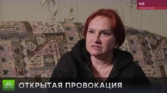 Женщина средних лет с темно-рыжими волосами сидит на пестром диване и напряженно смотрит в камеру