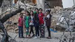 Palestinian girls play in rubble in Beit Hanoun, northern Gaza