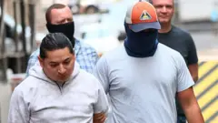 Agentes enmascarados detienen a un migrante en Nueva York.