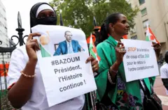 Des manifestants brandissent des pancartes devaDes manifestants se rassemblent devant l'ambassade du Niger à Paris
