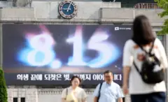 광복절 기념 문구 현수막 앞을 걷는 시민들