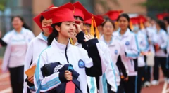 Senior three students from Rizhao Experimental High School don red mortarboards as they take part in the school's graduation ceremony on 16 May, 2025 in Rizhao, Shandong