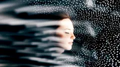 Wajah perempuan dengan latar belakang hitam.