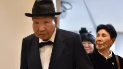 El ex boxeador profesional japonés Iwao Hakamada (izquierda), condenado a muerte por el asesinato de cuatro miembros de una familia en 1966 y liberado en 2014, y su hermana Hideko (derecha) se van después de una conferencia de prensa en Tokio el 25 de noviembre de 2019.