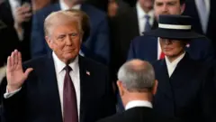 Donald Trump arahizwa nka Perezida wa 47 w'Amerika, arahizwa n'umukuru w'urukiko rw'ikirenga John Roberts, mu gihe Melania Trump afashe Bibiliya, mu nyubako ya US Capitol Rotunda, i Washington, DC