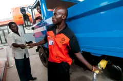 Un homme achète du carburant dans une station d'essence