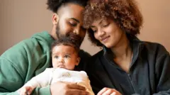 Pai, mãe e bebê, juntos e sorrindo