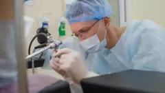 Profissional de assistência médica opera um instrumento em uma sala hospitalar