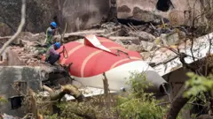 Funcionarios inspeccionan los restos del avión de pasajeros de Air India en el lugar del accidente, cerca del Aeropuerto Internacional Sardar Vallabhbhai Patel en Ahmedabad, estado de Gujarat, oeste de la India, el 14 de junio de 2025.