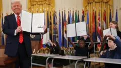 美國總統特朗普拿著簽署的行政命令和一群小孩的合影