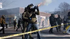 A federal agent confronts demonstrators in Minneapolis