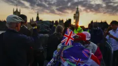 議會大廈前舉著國旗的排隊男子