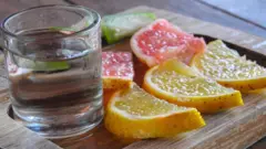 Shot de destilado con pedazos de fruta al lado.