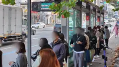 광역버스 입석 승차 금지 첫날인 18일 오전 경기 수원시 팔달구 우만동4단지 버스정류장 앞에서 승객들이 줄을 서 버스를 기다리고 있다