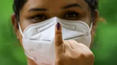 A Sri Lankan voter wearing a face mask shows the indelible ink mark on her finger after casting vote for the Parliamentary Election at a polling center Colombo, Sri Lanka on August 5, 2020. (Photo by Tharaka Basnayaka/NurPhoto via Getty Images)