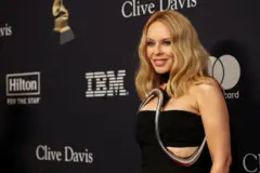 Kajli Minog u crnoj haljini, gleda u kameru 