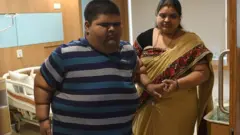 Meher Jain, 14, with his mother Pooja Jain (R) walk in his hospital room in New Delhi on July 6, 2018. - Meher underwent a successful gastric bypass surgery at the Max Super Speciality Hospital in New Delhi, after reaching 237kg (522 pounds) in December 2017. He was labelled by the hospital as the "heaviest teen in the world", and advised to shed the weight with a low calorie regime and the surgery in order to save his life. Since the surgery and drastic diet, the teen now weighs 196kg (432 pounds), the hospital said.