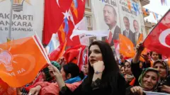 Bir kadın turuncu bir bayrak sallarken diğer elini de çenesine koymuş birini huşu içinde dinlemek istiyor.