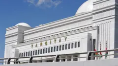 YARGITAY yazılı beyaz bir binanın üst bölümü görünüyor. Önünde üç bayrak gönderde ancak detayları seçilmiyor. 