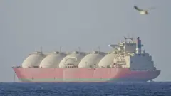 Um enorme navio-tanque vermelho no mar.