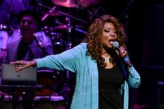 Gloria Gaynor en un escenario cantando.