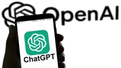  ChatGPT的标志显示在智慧型手机上，背景中可以看到 OpenAI 的标志。