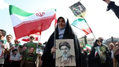 Uma mulher iraniana segura uma foto do supremo líder do Irã, o Aiatolá Mojataba Khamenei. 
