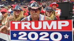 Trump 2020: Un hombre sostiene una pancarta a favor de Trump a la llegada al rally en Orlando, Florida.