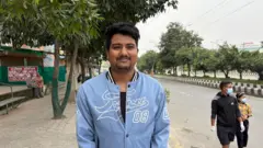 Um homem usando uma jaqueta azul e olhando para a câmera