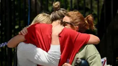 Женщины из местного сообщества обнимаются в павильоне Бонди в память о жертвах стрельбы на пляже Бонди в Сиднее 15 декабря 2025 года.