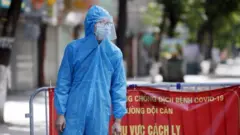Một người đàn ông mặc thiết bị bảo vệ cá nhân trong khu vực cách ly ở Hà Nội, ngày 13 tháng 8 năm 2021