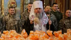 Metropolitan Epiphanius I, head of the Orthodox Church of Ukraine, sprinkles holy water to bless Easter cakes which are to be transferred to Ukrainian servicemen fighting on the frontline amid Russia's attack on Ukraine, during a ceremony at St Michael's Cathedral before Orthodox Easter, in Kyiv, Ukraine April 9, 2026.