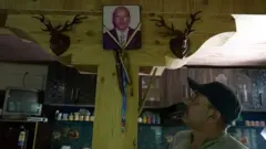 Punchok Dorjai, o filho mais velho de Morup, olhando para a foto emoldurada de seu pai.