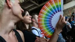 A participant holds a fan with rainbow colours during the lesbian, gay, bisexual and transgender (LGBT) Pride Parade in Budapest on July 24, 2021.